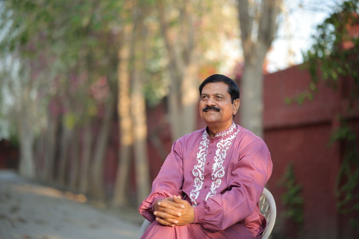 Anando seated in the garden, smiling